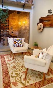 莫埃达Pousada Boutique das Pedras的客厅配有两把白色椅子和地毯