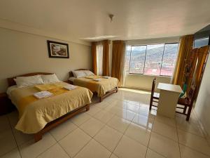 阿亚库乔Illari Wari l - Hotel Sauna的酒店客房设有两张床和窗户。