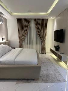 哈科特港Numdor Apartments By The Bond的一间卧室配有一张大床和电视