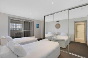 安特兰斯Ocean Parade - Penthouse - Ocean Views的酒店客房,设有两张床和镜子