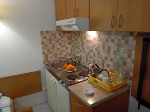 特雷比涅Vila Centar的厨房配有水槽和一碗橙子