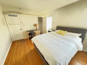 蒙特利公园市Cozy Home in Prime Location的卧室配有一张白色大床和黄色枕头