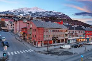 纳尔维克Narvik Hotel Wivel的一条有建筑和山的城市街道