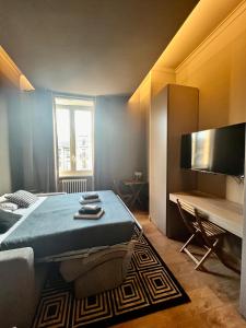 米兰NEW LUXURY STUNNING BILO APARTMENT IN THE HEART OF MILAN MOSCOVA的一间卧室配有一张床、一台电视和一张沙发
