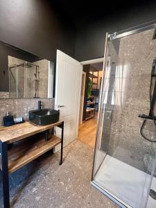 米兰NEW LUXURY STUNNING BILO APARTMENT IN THE HEART OF MILAN MOSCOVA的一间带水槽和玻璃淋浴的浴室