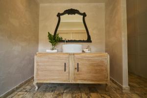 利马Pucllana BBBoutique的浴室设有水槽和梳妆台上的镜子