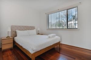YarralumlaRestful Canberra Retreat in Spacious Terrace Home的卧室配有一张大白色床和窗户