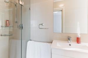 YarralumlaRestful Canberra Retreat in Spacious Terrace Home的带淋浴、盥洗盆和镜子的浴室