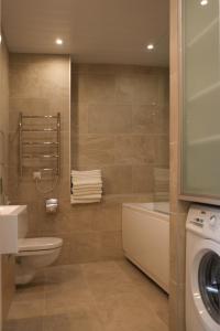 塔林我的公寓的浴室配有卫生间水槽和洗衣机。