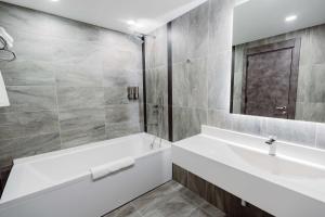 巴统Best Western Plus Batumi的白色的浴室设有浴缸和水槽。