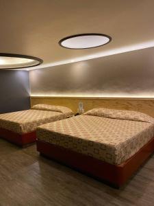 墨西哥城Hotel Gran Vía的配有2张床的客房,配有2盏灯