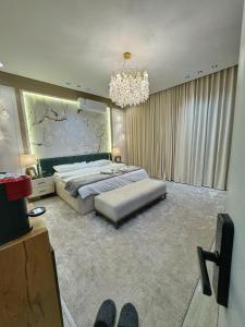 利雅德Master room with private bathroom share entrance的一间大卧室,配有一张大床和吊灯