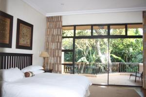 巴利托14 Zimbali Chalets的一间卧室设有一张床和一个大窗户