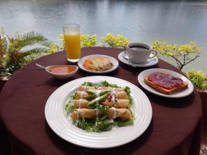 San Juan Bautista TuxtepecHotel Fragata的餐桌,盘子上放着食物,还有一杯橙汁