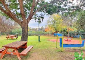 Gan H̱ayyimSpacious and Peaceful 2BD with a Garden & Parking的一个带野餐桌和树的公园