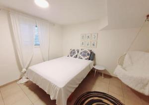 Gan H̱ayyimSpacious and Peaceful 2BD with a Garden & Parking的白色的客房设有床和窗户。