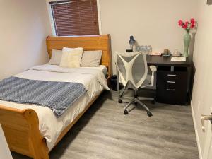 基奇纳Cozy room D的一间卧室配有一张床、一张桌子和一把椅子