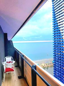 巴统ORBI CITY batumi的阳台配有椅子,享有海景
