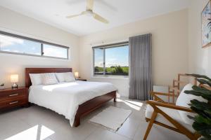 凯阿玛Sea&Country Kiama - Stunning Views-Relaxing-Spacious-Deck-EVC的一间卧室设有一张床和一个大窗户
