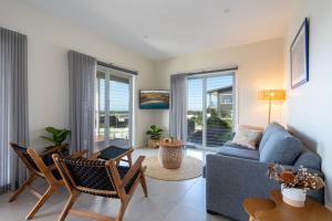 凯阿玛Sea&Country Kiama - Stunning Views-Relaxing-Spacious-Deck-EVC的客厅配有蓝色的沙发和椅子
