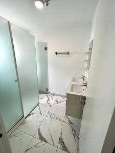 奥埃拉斯Oeiras Beach guest house的一间带水槽和镜子的浴室