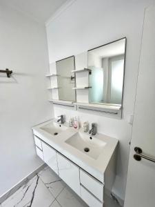 奥埃拉斯Oeiras Beach guest house的白色的浴室设有水槽和镜子