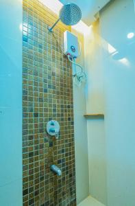 公主港Hotel Palacio Puerto Princesa的一间带淋浴的浴室和瓷砖墙