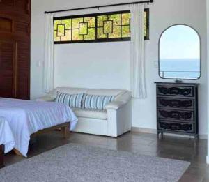 多米尼克Villa Del Mar 2 Spectacular ocean view!的一间带沙发、窗户和镜子的卧室