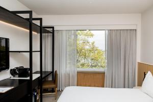 珀斯Quay Perth的一间卧室配有一张床、一张书桌和一个窗户。
