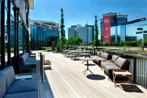 阿姆斯特丹阿姆斯特丹竞技场阿特拉斯公园万怡酒店的大楼内一个带沙发和桌子的甲板