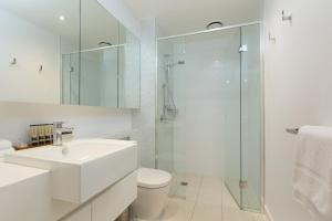 墨尔本The Sebel Melbourne Docklands Hotel的白色的浴室设有水槽和淋浴。