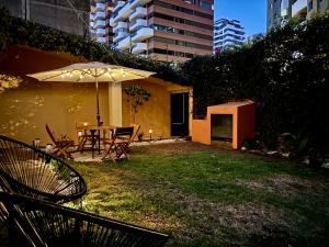 危地马拉NoMAD House的庭院配有遮阳伞和桌椅。
