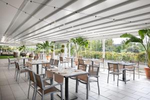 罗马罗马中心公园万豪酒店的餐厅设有桌椅和窗户。