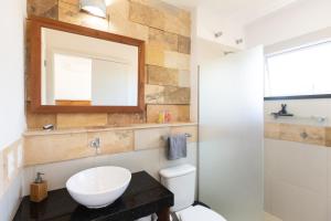 卡姆布库Kite Dream Cumbuco Apartments 60 & 120qm的一间带水槽、卫生间和镜子的浴室