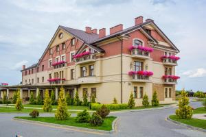 利沃夫潘斯卡戈拉酒店的一座大建筑,阳台上摆放着粉红色的鲜花