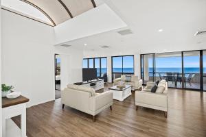科夫斯港太平洋塔海滩度假酒店的客厅配有白色家具,享有海景。