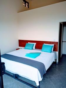 TilaránVILLA SIMONE FRENCH ECOLODGE的一间卧室配有一张带蓝色枕头的大床