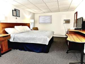 Wellsville巴基特汽车旅馆的一间卧室配有一张床、一张桌子和一台电脑