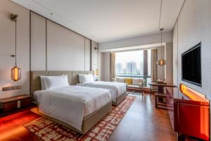 北京北京西南华邑酒店（免费客房升级）的一间卧室配有一张大床和电视