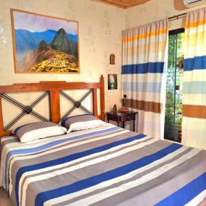 亚松森La Petite Maison的卧室配有蓝色和白色的床和窗户。