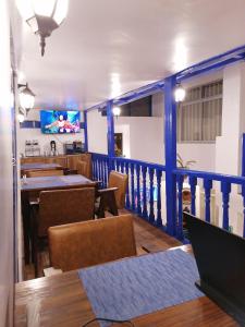 库斯科El Ave Azul Boutique Hotel Cusco的一间带桌椅和电视的用餐室