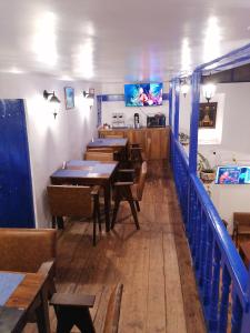 库斯科El Ave Azul Boutique Hotel Cusco的用餐室设有木桌和蓝色栏杆