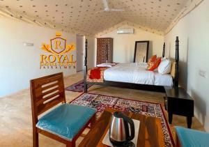 斋沙默尔Royal Empire Resort Jaisalmer的卧室配有一张床和一张桌子及椅子