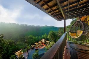 帕洋安Nandini Jungle by Hanging Gardens的一个带吊床的户外阳台和一个度假村