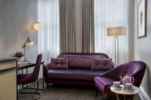奥克兰Fable Auckland, MGallery的客厅配有紫色沙发和桌子