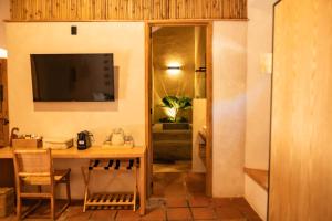 ComalaLa Paranera Hotel & Relax的客房设有桌子、电视和书桌。