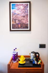 列城ANGKASA LADAKH RESORT的一张桌子、茶壶和墙上的照片
