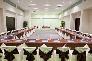 阿约拉港索利马尔酒店的一个带长桌和椅子的大型宴会厅