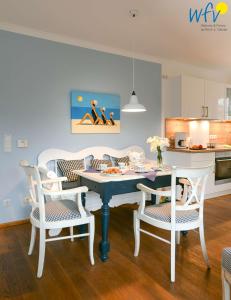 于斯德Luv und Lee - Ferienwohnung Juister Stuv的厨房以及带桌椅的用餐室。