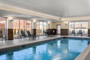 开普吉拉多Fairfield by Marriott Inn & Suites Cape Girardeau的大楼内一个带椅子和桌子的游泳池